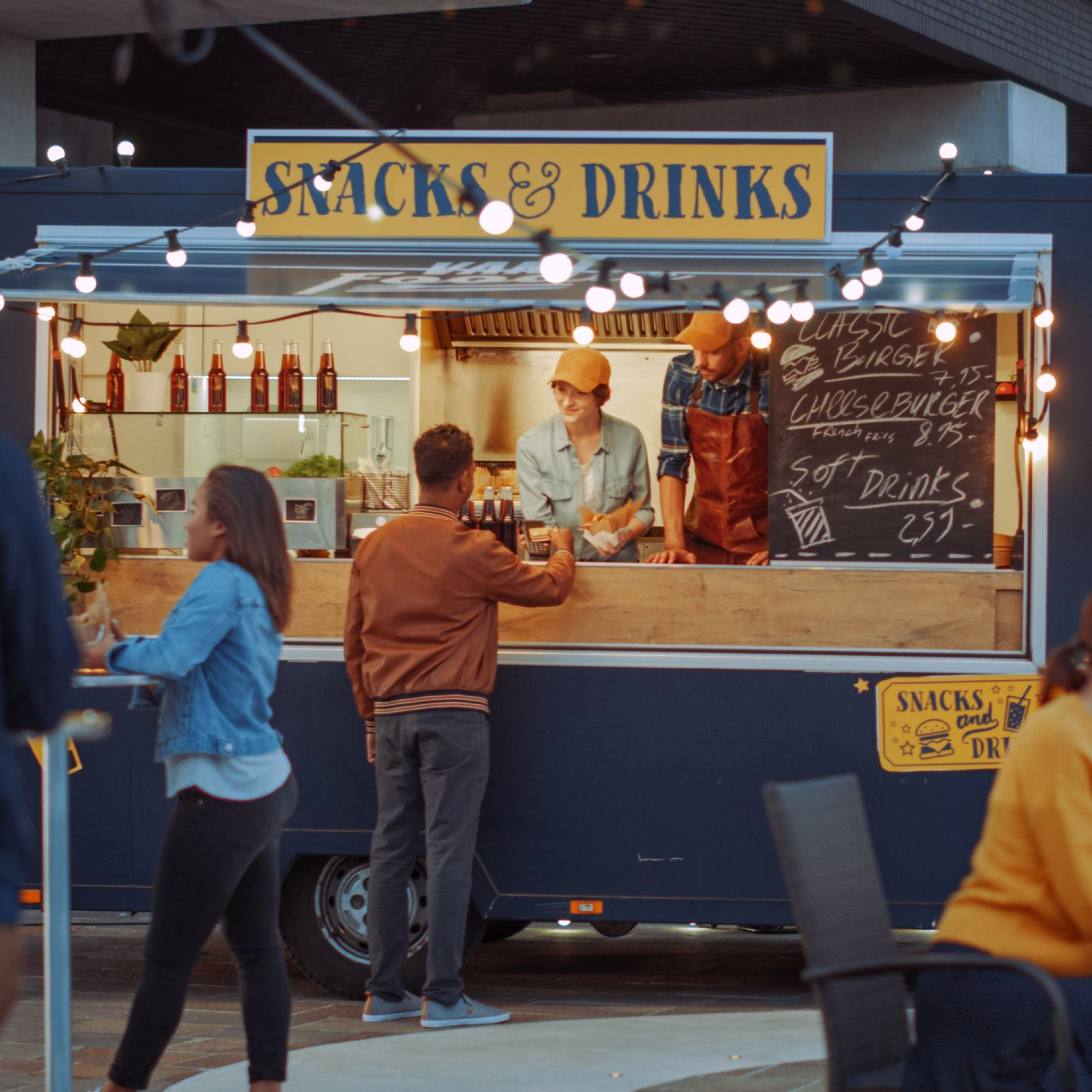 People buying from the Snacks and Drinks Truck outside at night