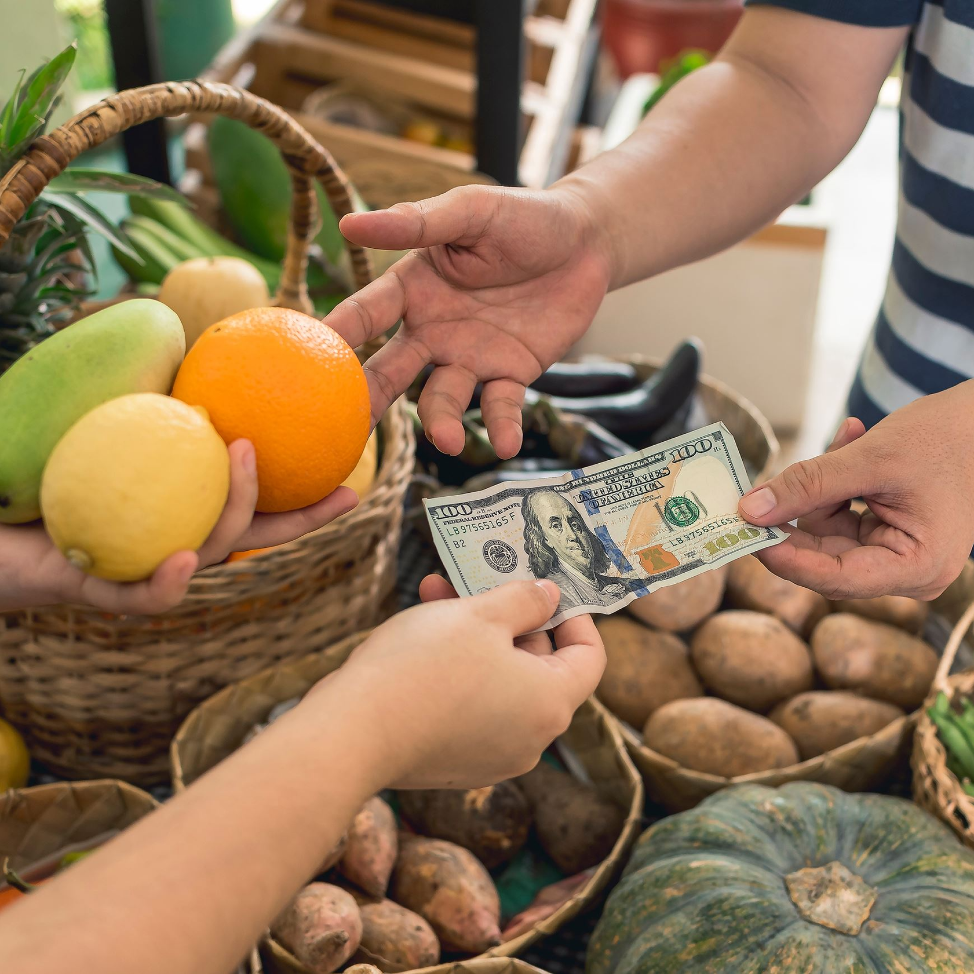 People at a market purchasing produce